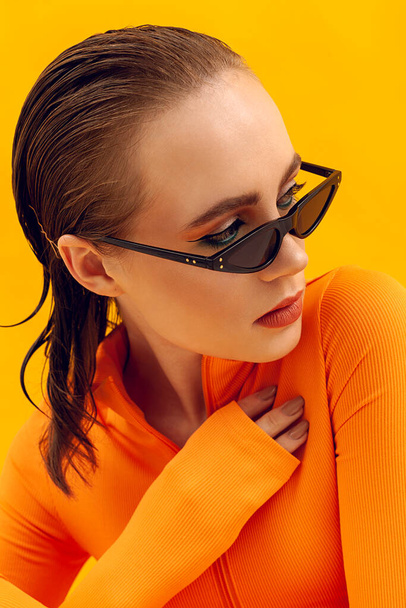 stylish portrait of a girl in trendy glasses on a yellow background - Fotoğraf, Görsel