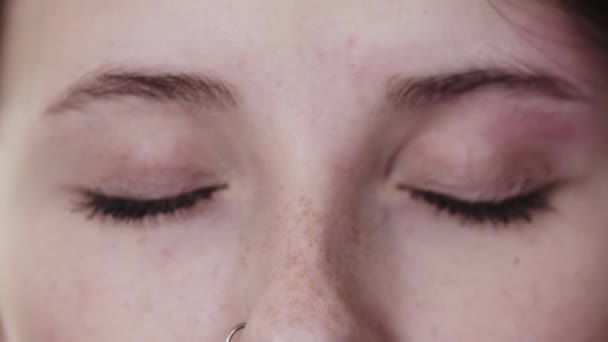 Vahaus pieniä hiuksia välillä kulmakarvat kaunis nainen harmahtavan vihreät silmät - Materiaali, video