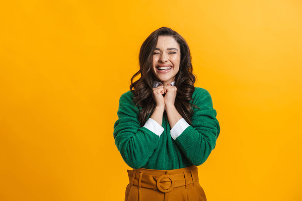 Portrait of a happy smiling casual woman standing over yellow background rejoycing - Photo, image