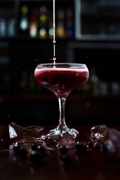 roter Cocktail mit Beeren, auf einem Hintergrund aus Eis und Schaumstoff - Foto, Bild