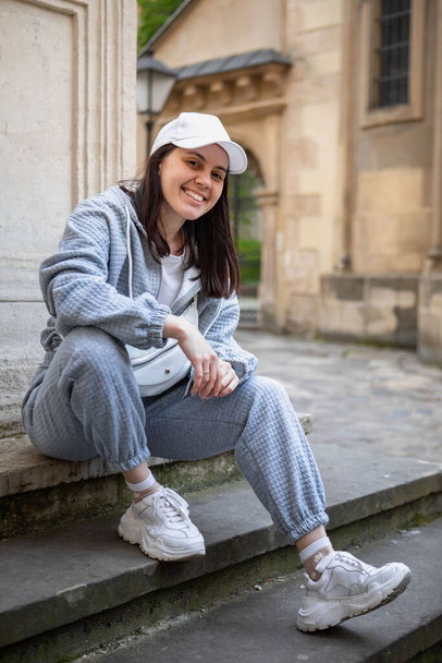 pretty smiling woman posing in baggy sport cloth outdoors - 写真・画像