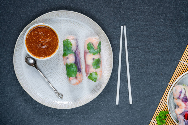 vietnamese spring rolls with prawns, carrot, cucumber, red cabbage and spicy sauce. Healthy eating - Fotografie, Obrázek