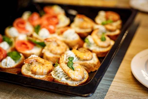 Bruschetta with shrimps on a black tray - Foto, Imagem