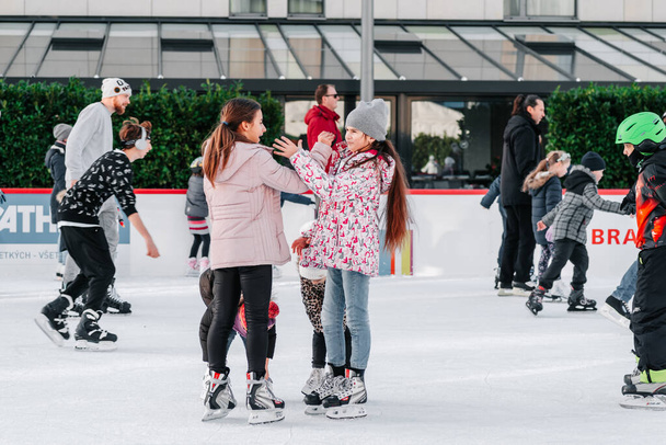 Slovakia.Bratislava.28.12.2018 .Soft,Selective focus.Group of teenage friends ice skating on an ice rink.People ice skating on the City Park Ice Rink in Europe. Enjoying winter outdoor activities. - Photo, Image