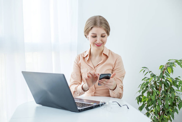 Femme avec des lunettes portant un chemisier beige. Étudiante utilise ordinateur portable et Internet dans les études. - Photo, image