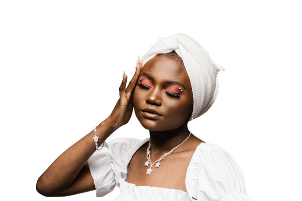 Beauty portrait of black muslim woman weared white dress and headscarf on white background. Softness and wellness of body and skin - Photo, Image