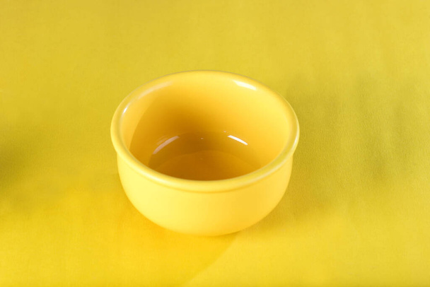 gelbe Porzellanschale isoliert auf gelbem Hintergrund, Küchenutensilien - Foto, Bild