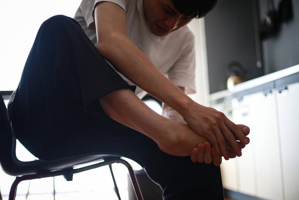 asian man  suffering from leg pain at home - Foto, Imagem