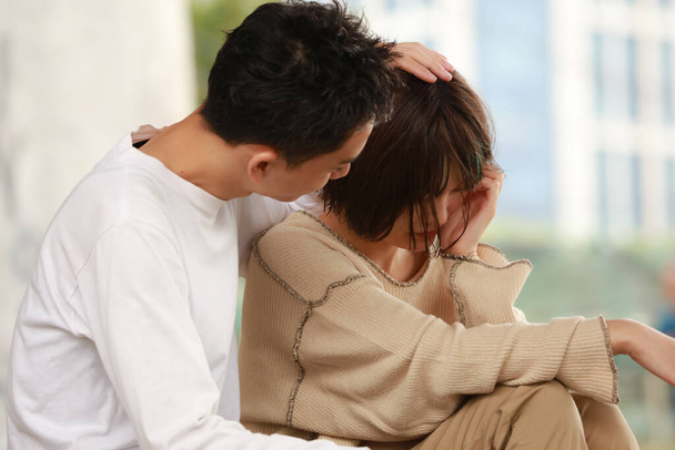 азиатка утешает своего грустного мужа - Фото, изображение