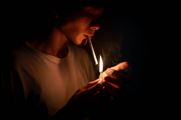 young asian man lighting a cigarette - 写真・画像
