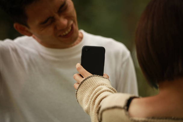 Женщина показывает мужчине экран смартфона - Фото, изображение