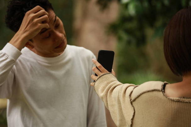 Una donna che mostra uno schermo dello smartphone a un uomo - Foto, immagini