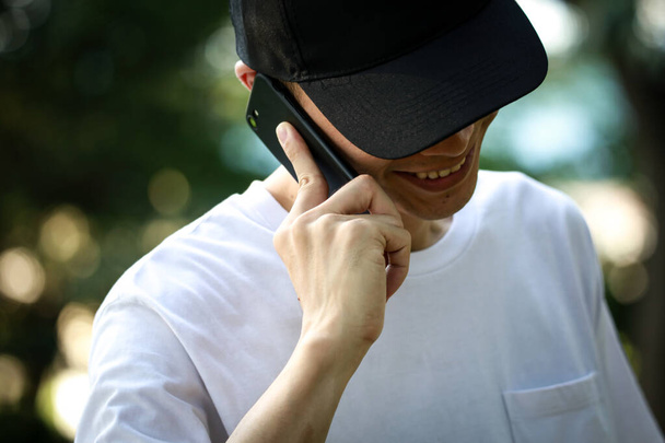 junger asiatischer Mann spricht auf Smartphone - Foto, Bild