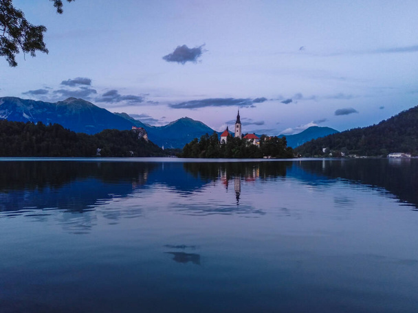 Sunset over Bled lake with Church of the Assumption of Maria and Bled Castle in Slovenia - Valokuva, kuva