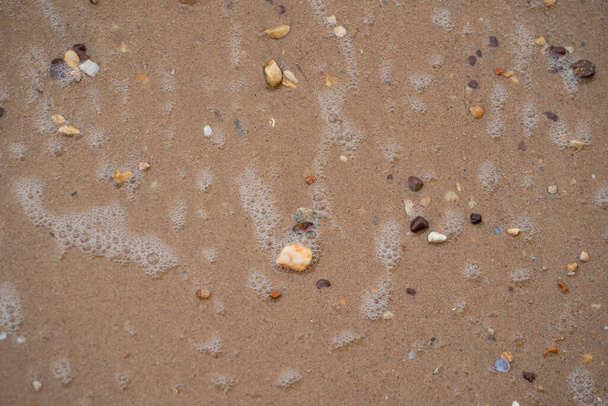 Számtalan kavics hullám habbal a tengerparton. Szelektív fókuszpontok - Fotó, kép