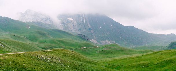 Brume descend des montagnes dans une vallée dans le parc national de Durmitor - Photo, image