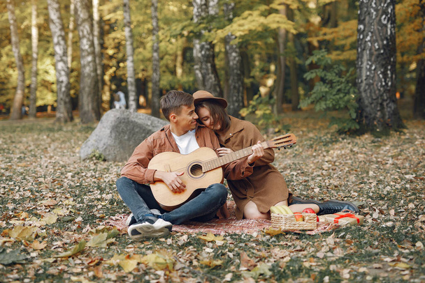 美しいカップルは秋の公園で時間を過ごす - 写真・画像