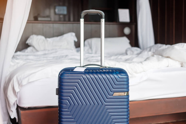 Kék poggyász a modern szállodai szobában, ajtónyitás után. Utazás, szolgáltatás, utazás, utazás, nyaralás és nyaralás ideje - Fotó, kép