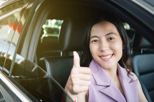 Woman adjusting an air grille on the vehicle dashboard while driving on the road during the rain. Climate control system in the modern car with cool and warm air conditioner. Temperature control. - 写真・画像