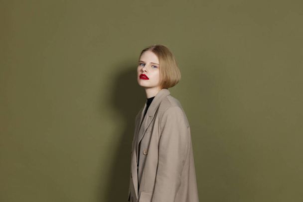 fashionable woman in coat red lips fashion studio model unaltered - Foto, afbeelding