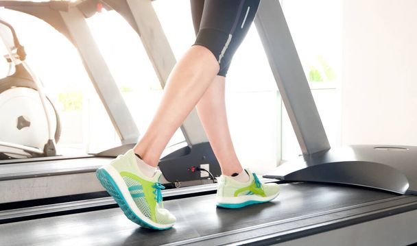 noha ženy běží na běžeckém pásu v tělocvičně, který běžec atletické běžecké boty. Zdraví a sport koncept pozadí, - Fotografie, Obrázek