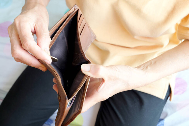 mão de mulher pegar uma moeda de ouro da carteira marrom para ser usado nas compras.. Dinheiro e gastar ideias
 - Foto, Imagem