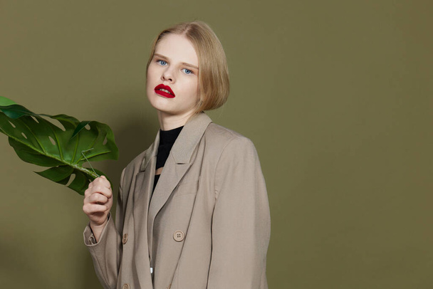 pretty woman in coat red lips fashion palm leaf studio model unaltered - Zdjęcie, obraz