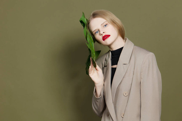 blond vrouw groen palm blad jas helder make-up studio model ongewijzigd - Foto, afbeelding
