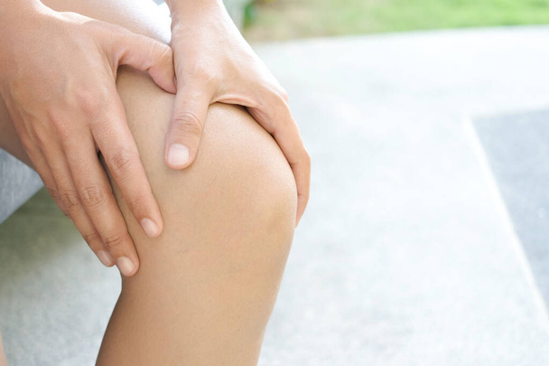 Knee pain .Woman stand on grass Her hand caught at the knee. Having painful feet and stretching muscles fatigue To relieve pain. health concepts. - Fotó, kép