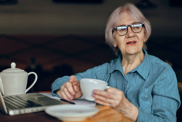 elderly woman in a cafe a cup of drink laptop Social networks unaltered - Fotografie, Obrázek