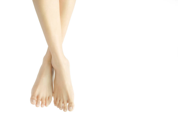 Beautiful female legs and feet on a white background.Concept beauty and hydration of the skin. - Фото, изображение