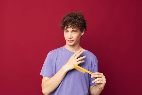 portrait of a young curly man in purple t-shirts with a comb Youth style - Fotografie, Obrázek