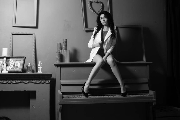 Gyönyörű szexi lány fehérnemű és kabát pózol a kamera a stúdióban, Fekete-fehér fotó - Fotó, kép