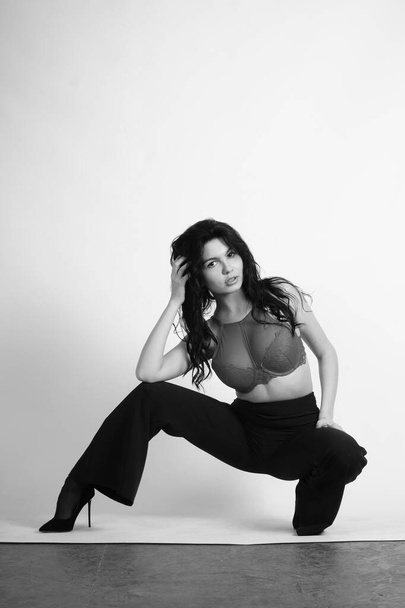 kaunis nuori nainen mustissa vaatteissa poseeraa studio - Valokuva, kuva
