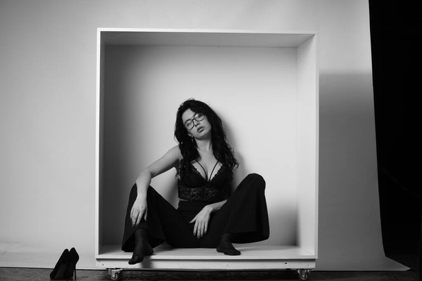 fekete-fehér portré gyönyörű szexi nő fekete ruhában pózol a stúdióban - Fotó, kép