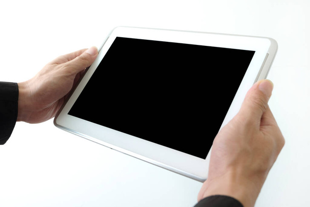 Die Hände der Menschen nutzen das Tablet, um Informationen zu finden und auf schwarzem Hintergrund zu unterhalten. - Foto, Bild