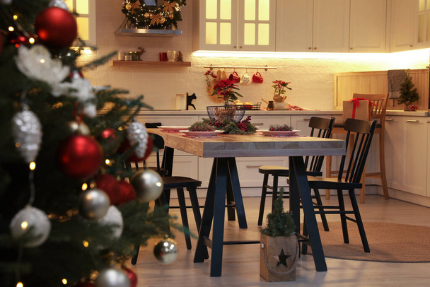 Cozy dining room interior with Christmas tree and beautiful festive decor - Valokuva, kuva