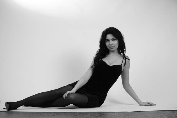 Schwarz-Weiß-Porträt einer schönen sexy Frau in schwarzer Kleidung, die im Studio posiert - Foto, Bild