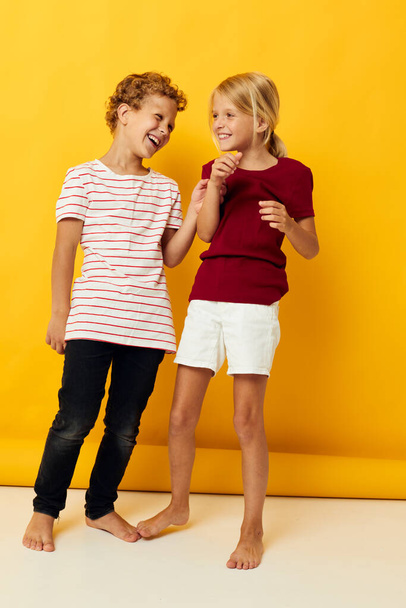 фотография положительного мальчика и девочки обнимающие моду детские развлечения на цветном фоне - Фото, изображение