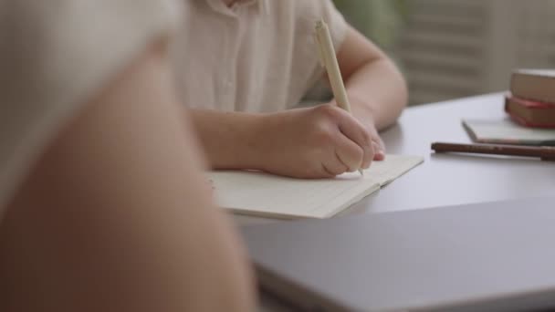 Slowmo toma de 11 años de edad, colegiala escribiendo en copybook, mientras que haciendo la asignación en casa junto con su mamá - Imágenes, Vídeo