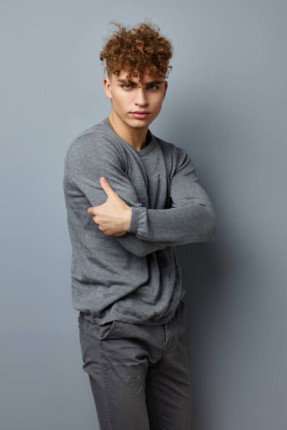 handsome young man in a gray sweatshirt fashion studio isolated background - Foto, Imagem
