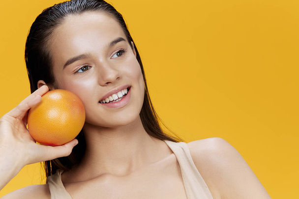 portré nő grapefruit kezében pózol tiszta bőr elszigetelt háttér - Fotó, kép
