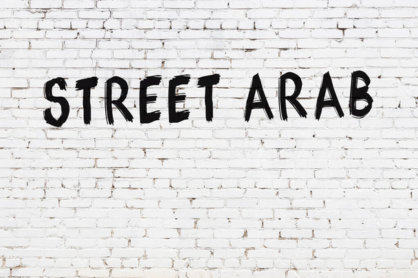 Witte bakstenen muur met inscriptie straat Arabisch handgeschreven met zwarte verf - Foto, afbeelding