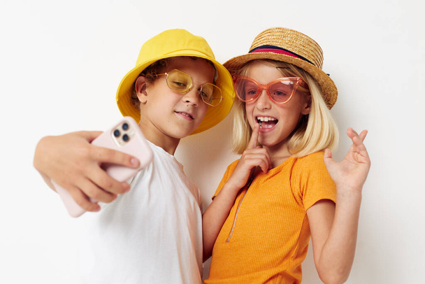children in hats with phone together friendship - Фото, изображение