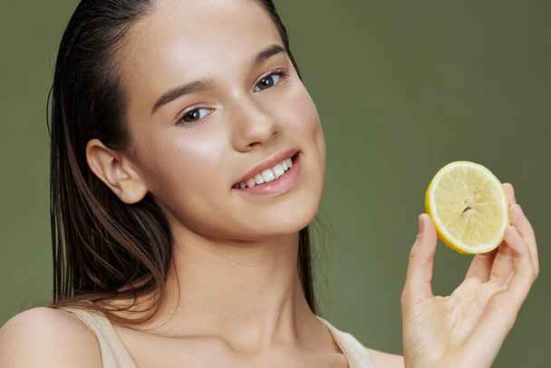 beautiful woman lemon in hands posing clean skin green background - Zdjęcie, obraz