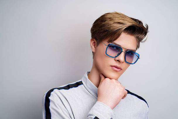 Hipster young guy in stylish glasses while looking at camera. Stylish hairstyle. Fashion man - Foto, immagini