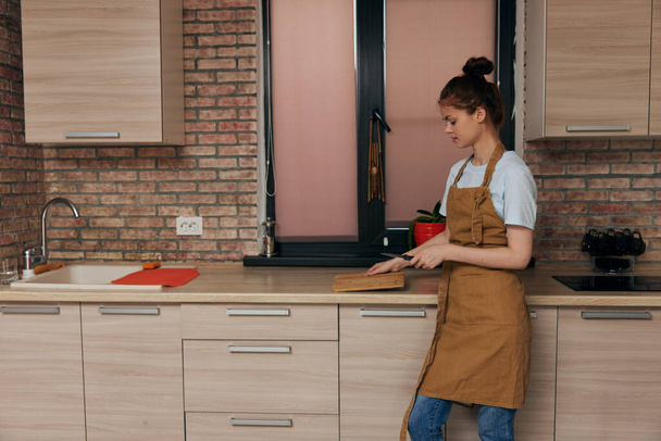 όμορφη γυναίκα κουζίνα διαμέρισμα κουζίνα κοπής επιτραπέζια σκεύη εσωτερικό μοντέρνο στυλ - Φωτογραφία, εικόνα