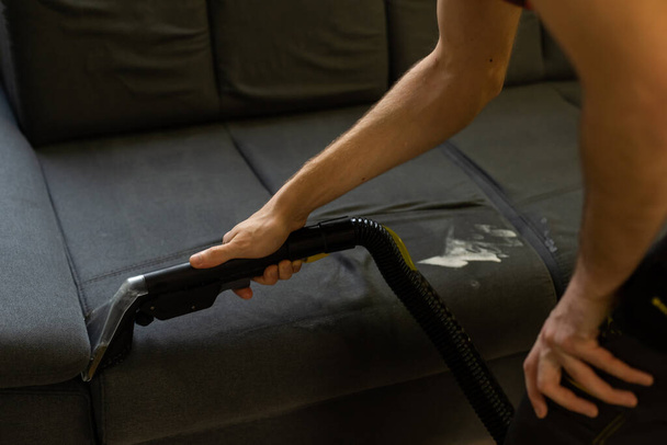 Hand cleaning a sofa with a steam cleaner, Home cleaning concept. - Photo, Image