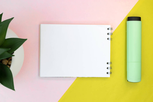 Notepad with a blank sheet on a colored background with a marker. - Photo, image