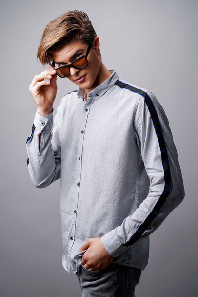 Male hairstyle concept. Handsome guy with stylish haircut in sunglasses over white background - Fotó, kép